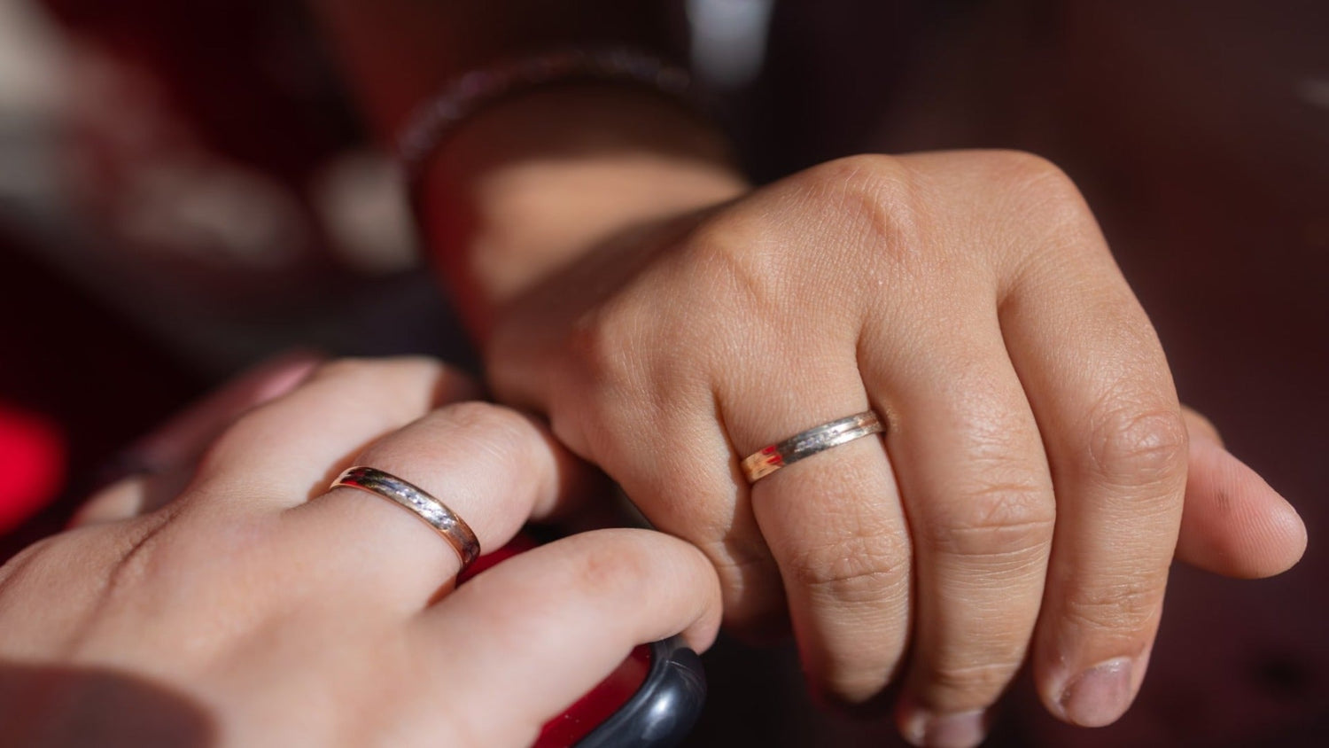 Close-up of fingers, both wearing wedding rings